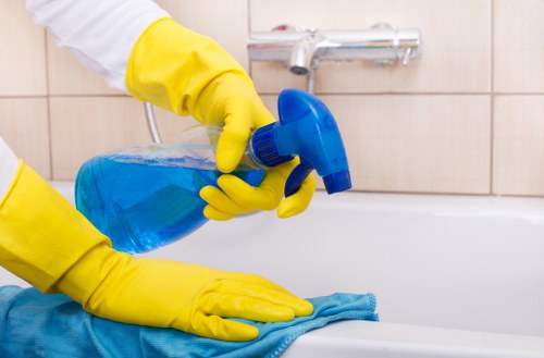 Person applying baking soda paste during oven cleaning